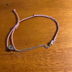 Lavender colored bracelet with gem in the middle then half chain